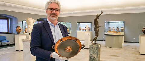 Wer den letzten Schluck trinkt, erblickt die Medusa. Jochen Griesbach-Scriba mit einer Trinkschale, die um etwa 540 vor Christus hergestellt wurde.