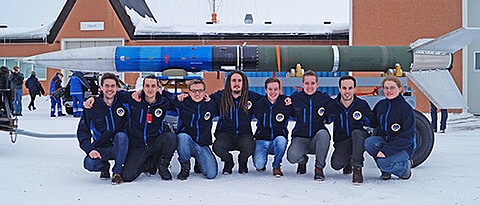 Schweden im März: Das Würzburger PATHOSTeam vor der REXUS20-Rakete. Von links: Moritz Aicher, Liviu Stamat, Kevin Chmiela, Felix Klesen, Dominik Wagner, Jonas Ehnle, Florian Kunzi und Elke Heidmann. (Foto: Team PATHOS)