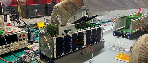 ADCS-Box (Attitude Determination and Control System) während des Einsetzens in das Qualifikationsmodell des InnoCube-Satelliten. 