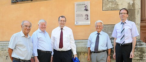 Unipräsident und ehemalige Professoren vor der neuen Gelehrtentafel