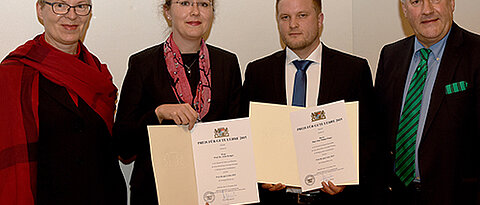 Preisverleihung in München: Wissenschaftsminister Ludwig Spaenle (rechts) und Vizepräsidentin Barbara Sponholz (Universität Würzburg, links) gratulieren den Preisträgern Anke Krüger und Philipp Singer (Foto: Friedrich Schmidt, LMU)