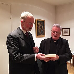 Dekan Prof. Dr. Heribert Hallermann (links) überreicht Bischof Dr. Friedhelm Hofmann (rechts) den neu erschienen 11. Band der Reihe "Würzburger Theologie"